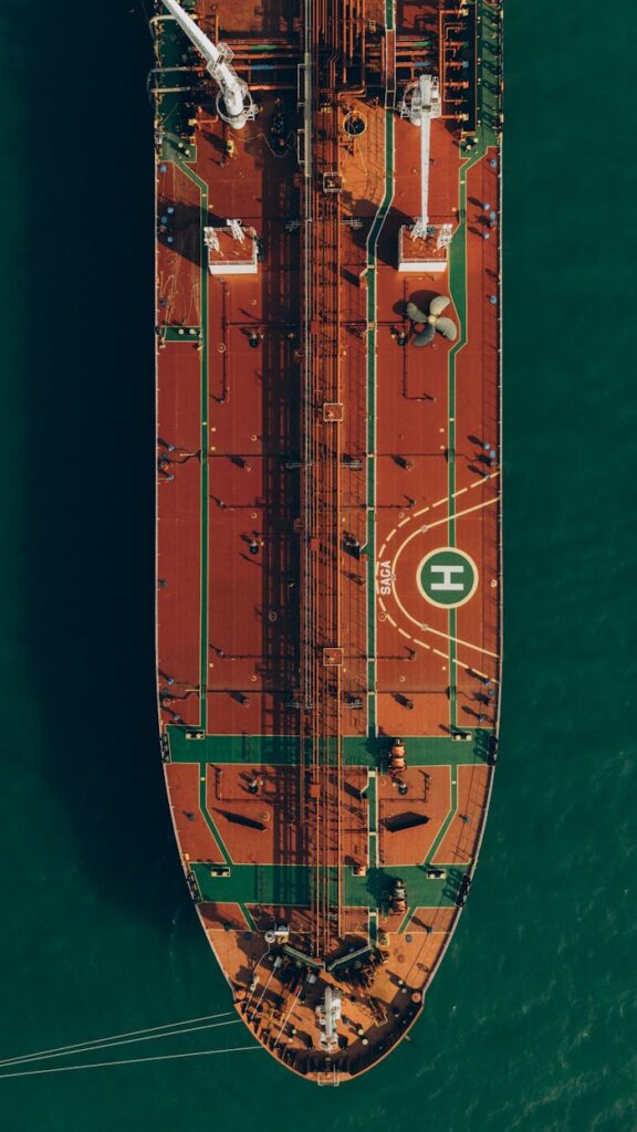 Top-down aerial view of a large cargo ship navigating through the ocean waters.